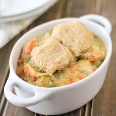 A casserole dish of chicken pot pie with drop biscuits on top.