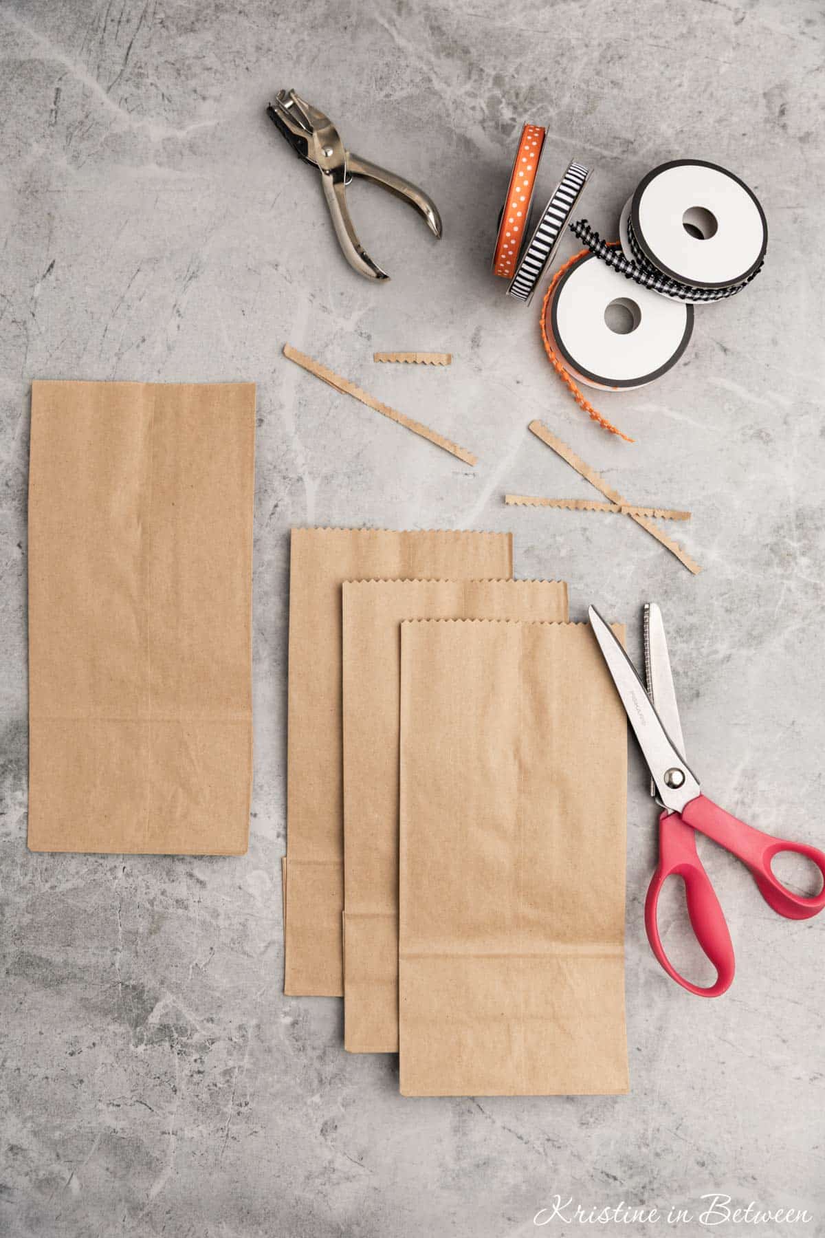 Pinking shears and brown paper bags with the tops cut off.