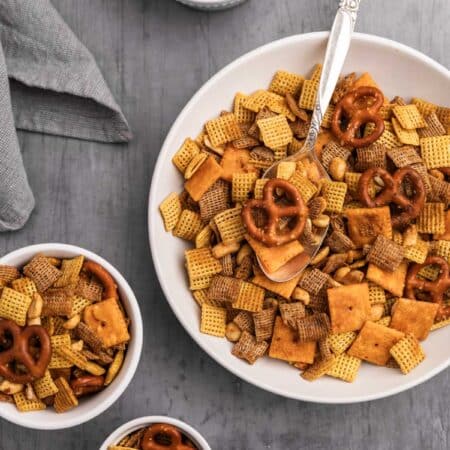 Snack mix in bowls with an antique spoon.