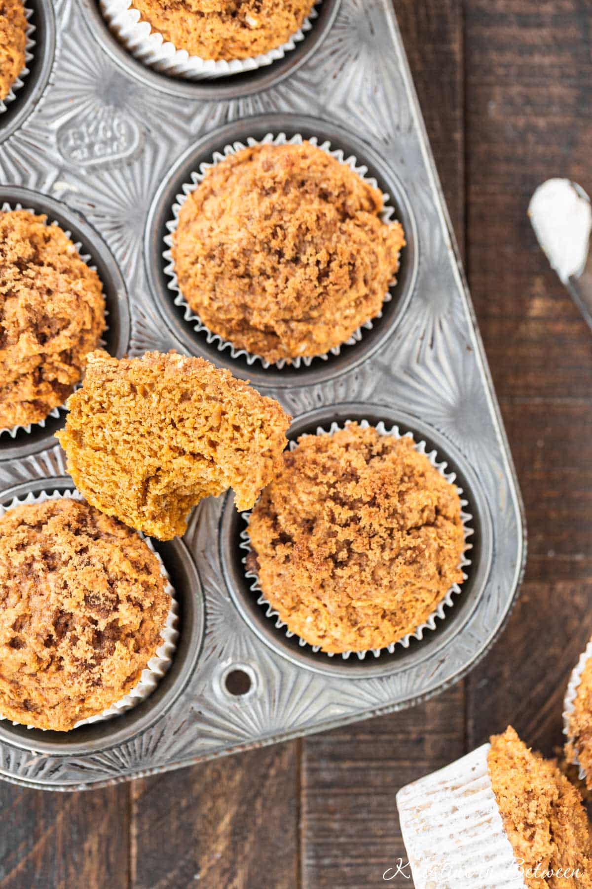 A pumpkin muffin cut in half to show the tender crumb inside.