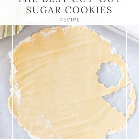 Cut-out sugar cookies sitting on a tray with a light green napkin in the background