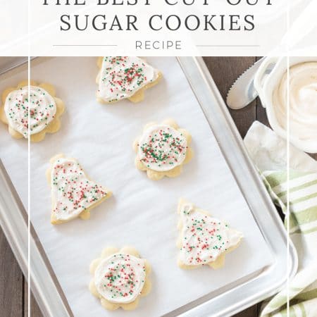 Cut-out sugar cookies sitting on a tray with a light green napkin in the background