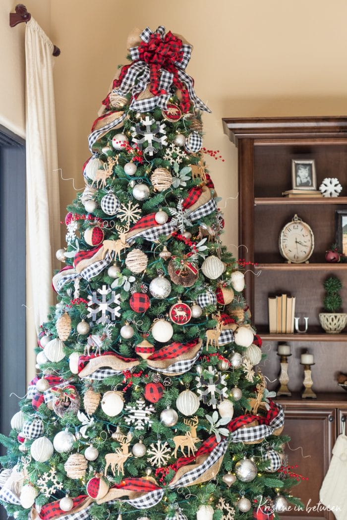 A decorated Christmas tree in red buffalo check, black and white buffalo check, and rustic snowflakes and cabin animals.