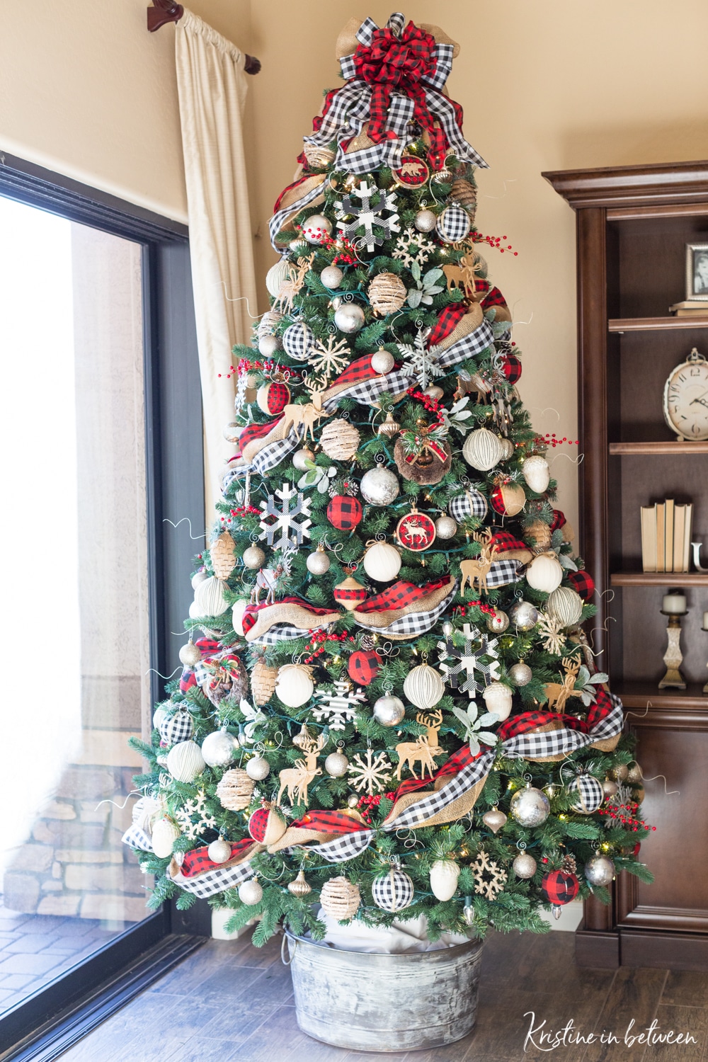 A decorated Christmas tree in red buffalo check, black and white buffalo check, and rustic snowflakes and cabin animals.
