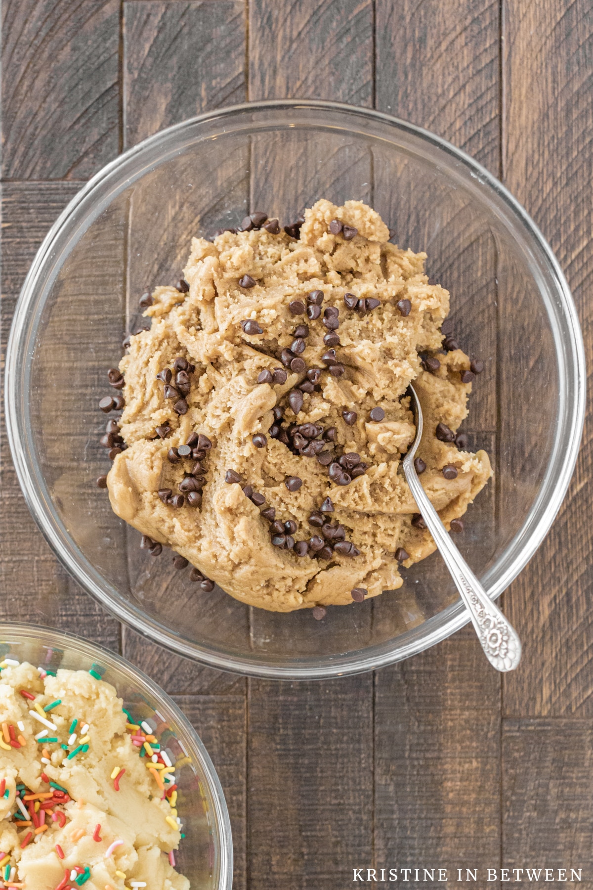 Basic cookie dough with chocolate chips in a glass bowl with a spoon.