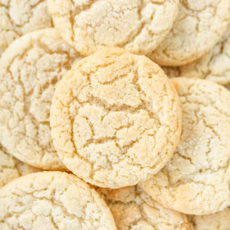 Sugar cookies stacked up on each other showing the detail in the tops of the cookies.