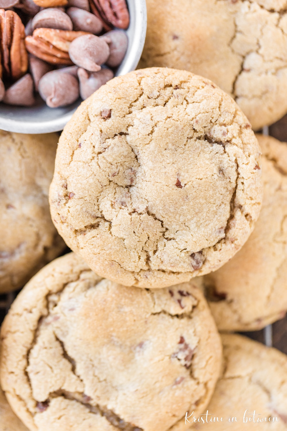 A closeup of the cookie showing the cracked top and some chocolate chips in a small bowl