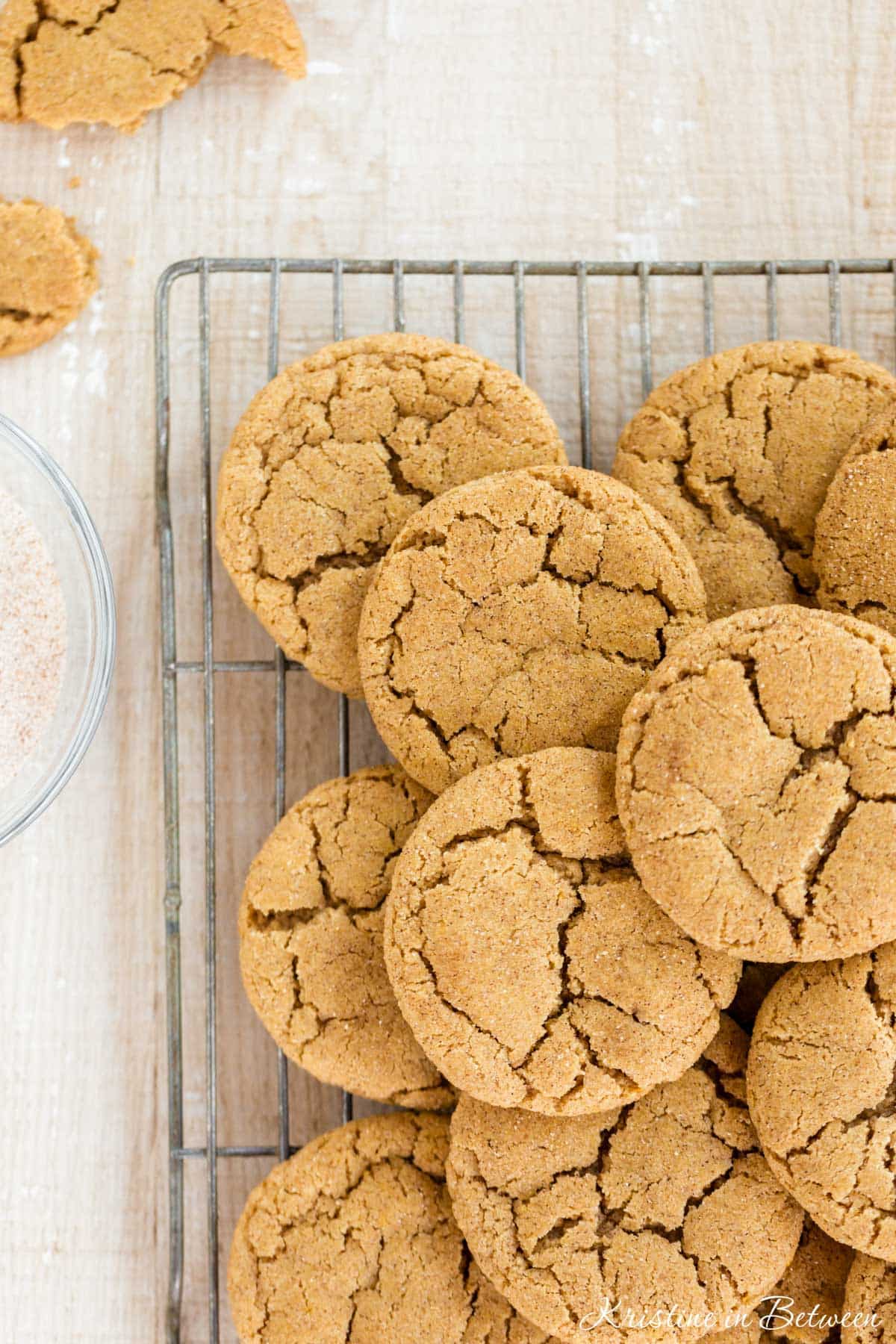 Cookies laying on a wire baking rack with a broken cookie off to the side.