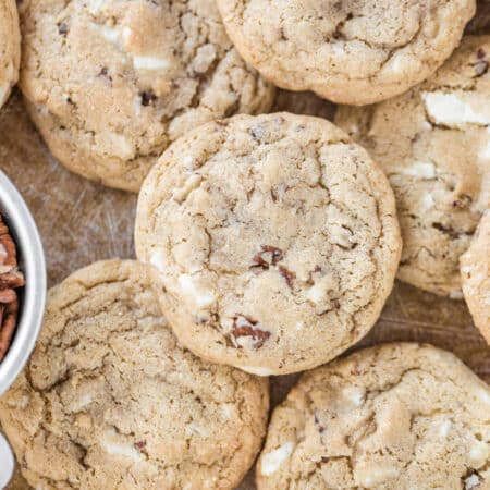 Cookies piled upon a baking sheet.
