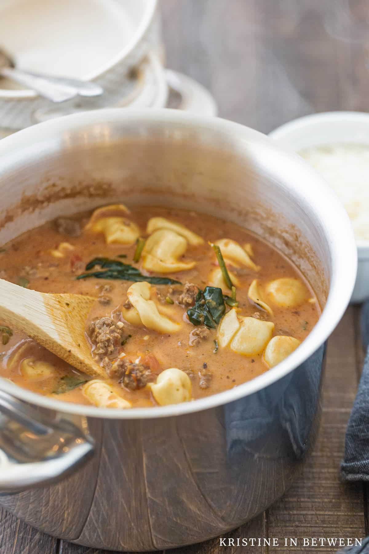 Soup in a pot with steam rising off of it.