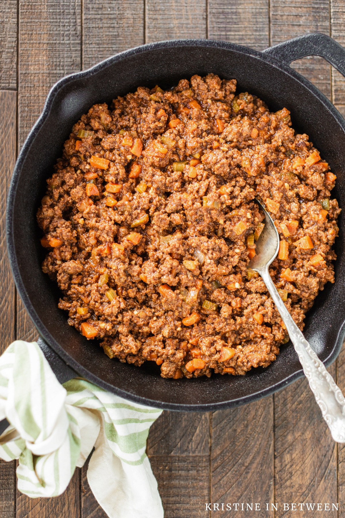 Sloppy joes in a cast iron pan with an antique spoon in it.