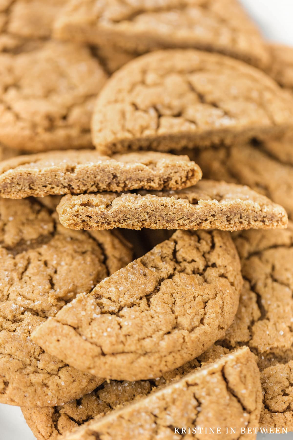 A soft gingersnap cookie cut in half to show the inside of the cookie.