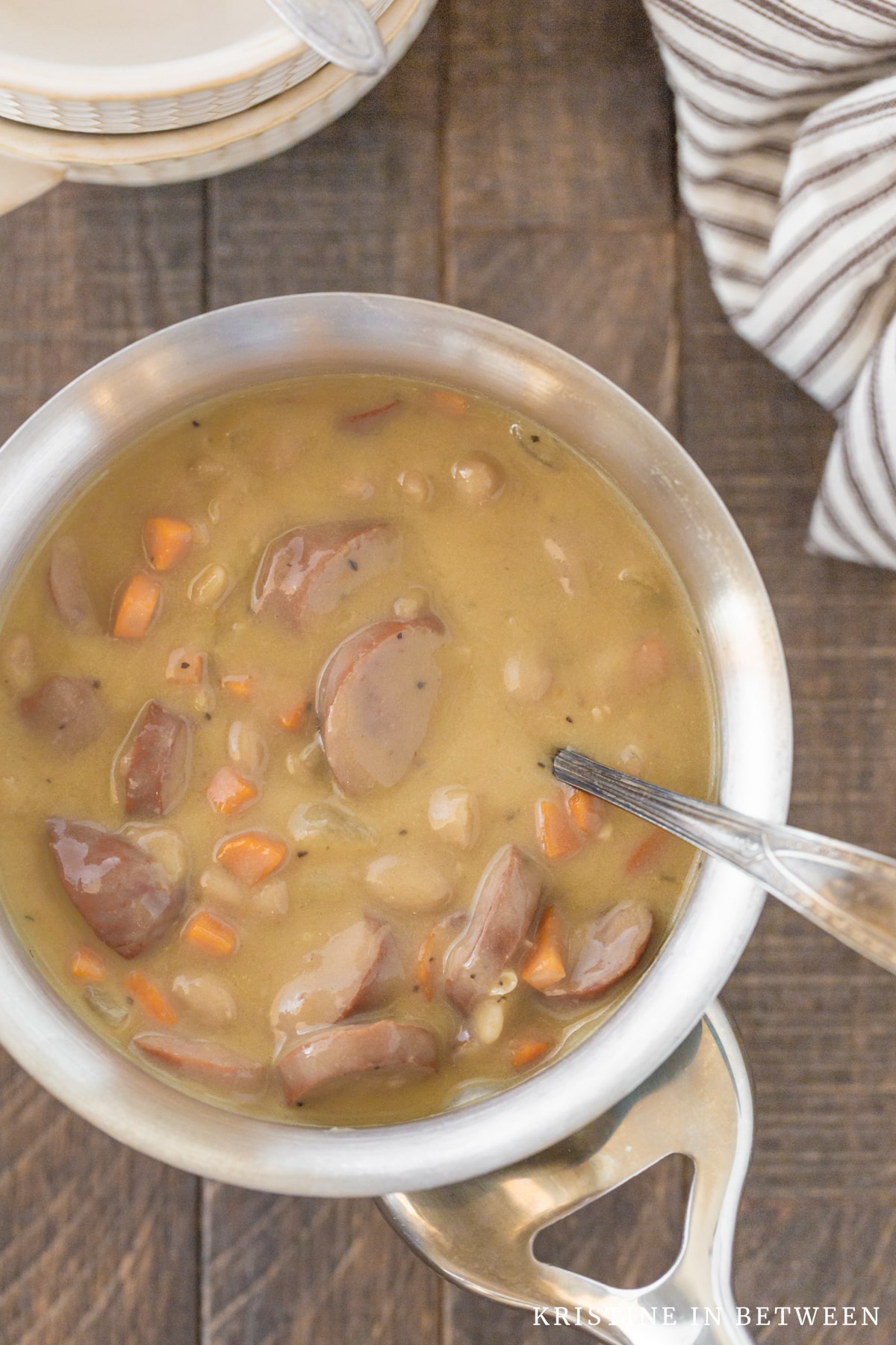 Kielbasa soup in the pan with a ladle in it.