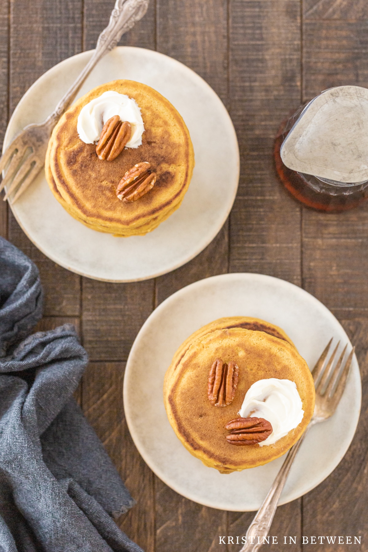 Two plates of pumpkin spice pancakes with forks sitting next to them.