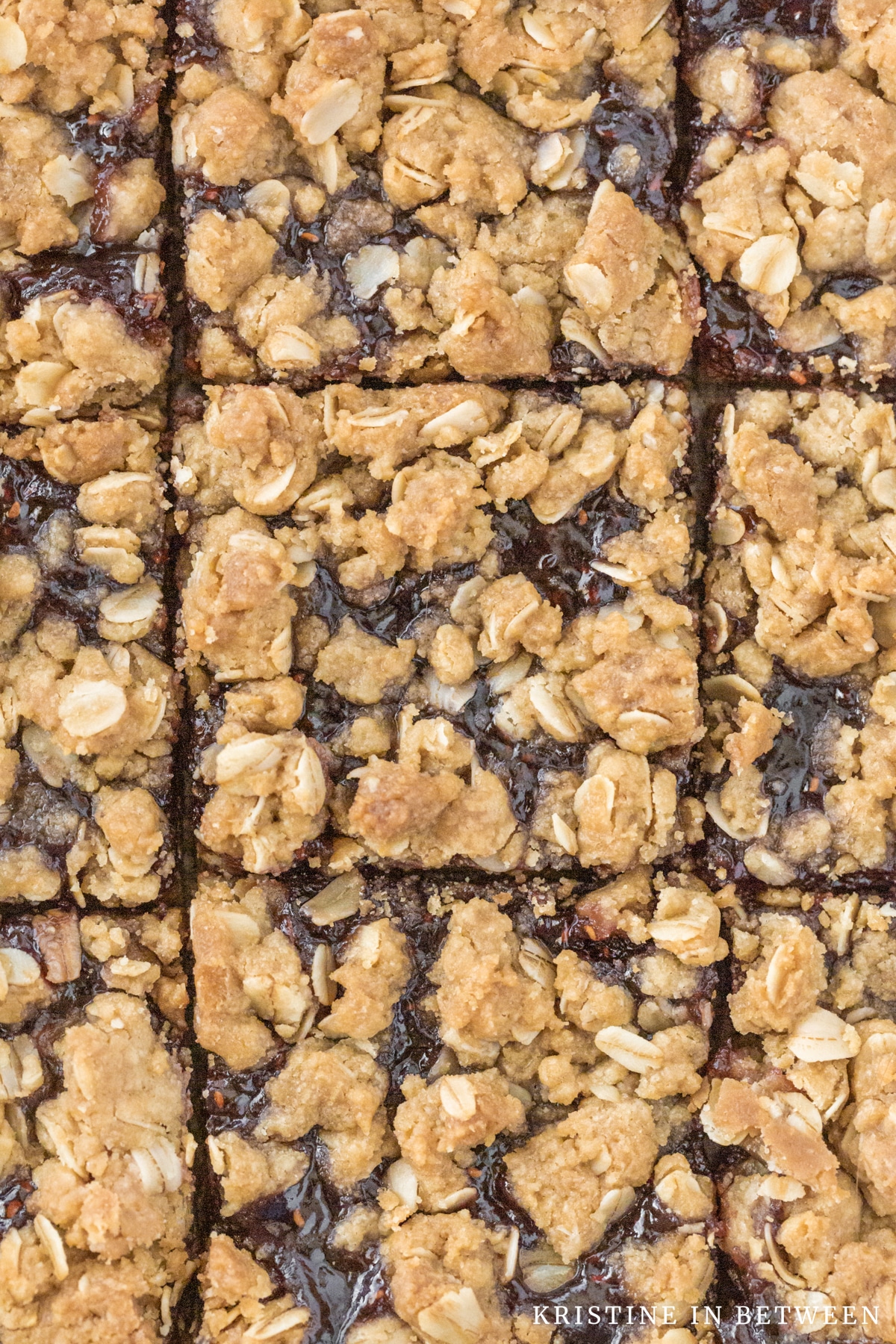 Raspberry jam bars cut in squares in a baking pan.