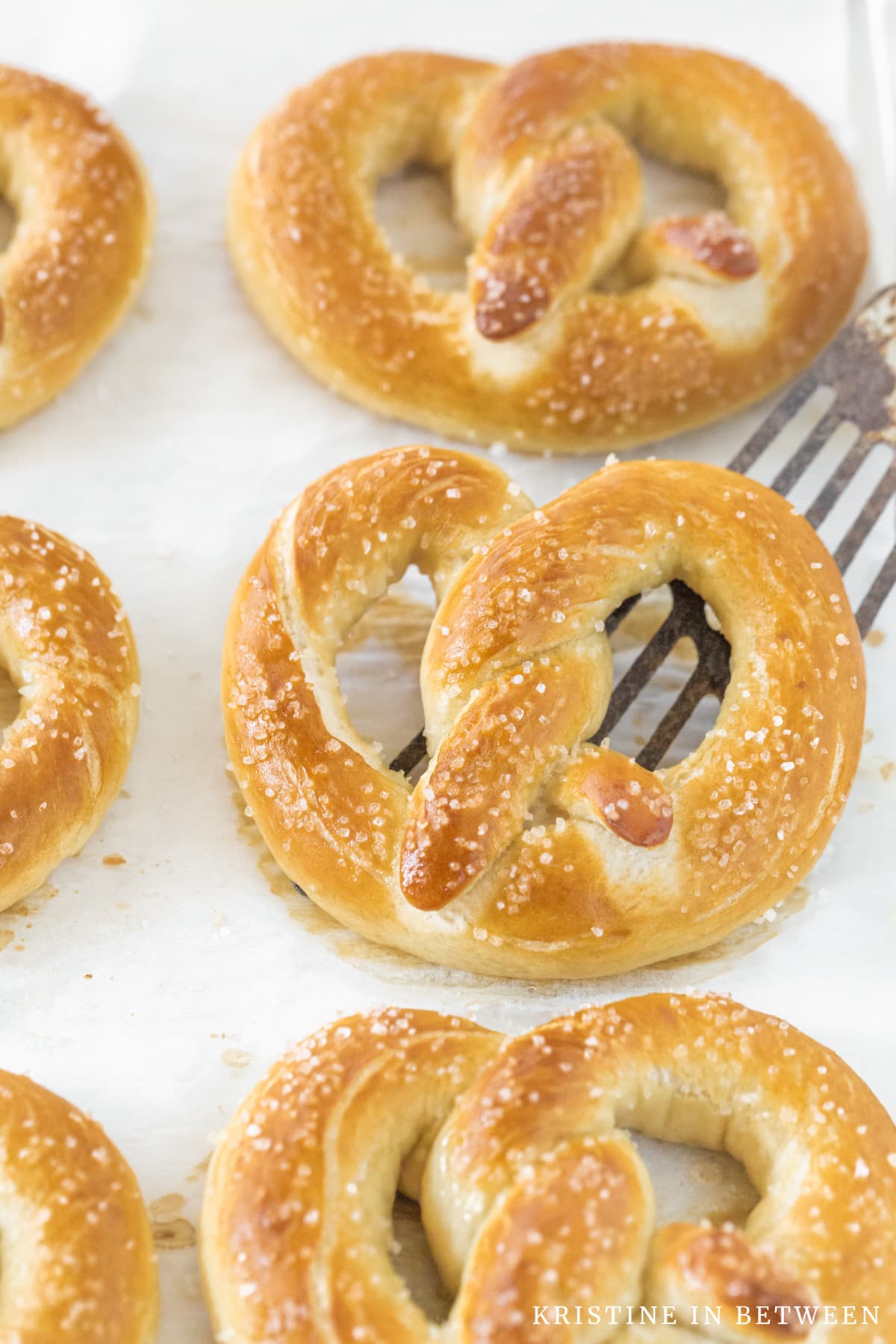 One soft pretzel sitting on an antique spatula.