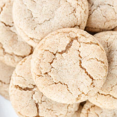 Snickerdoodle cookies stacked up showing the cracked tops.