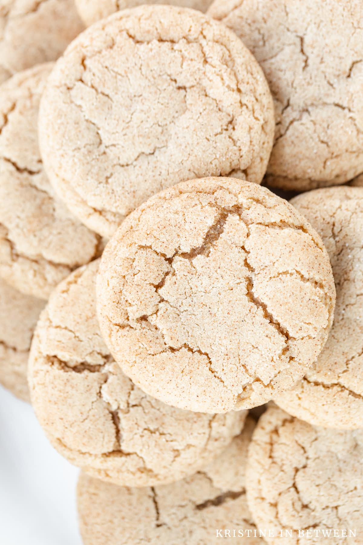 Snickerdoodle cookies stacked up showing the cracked tops.