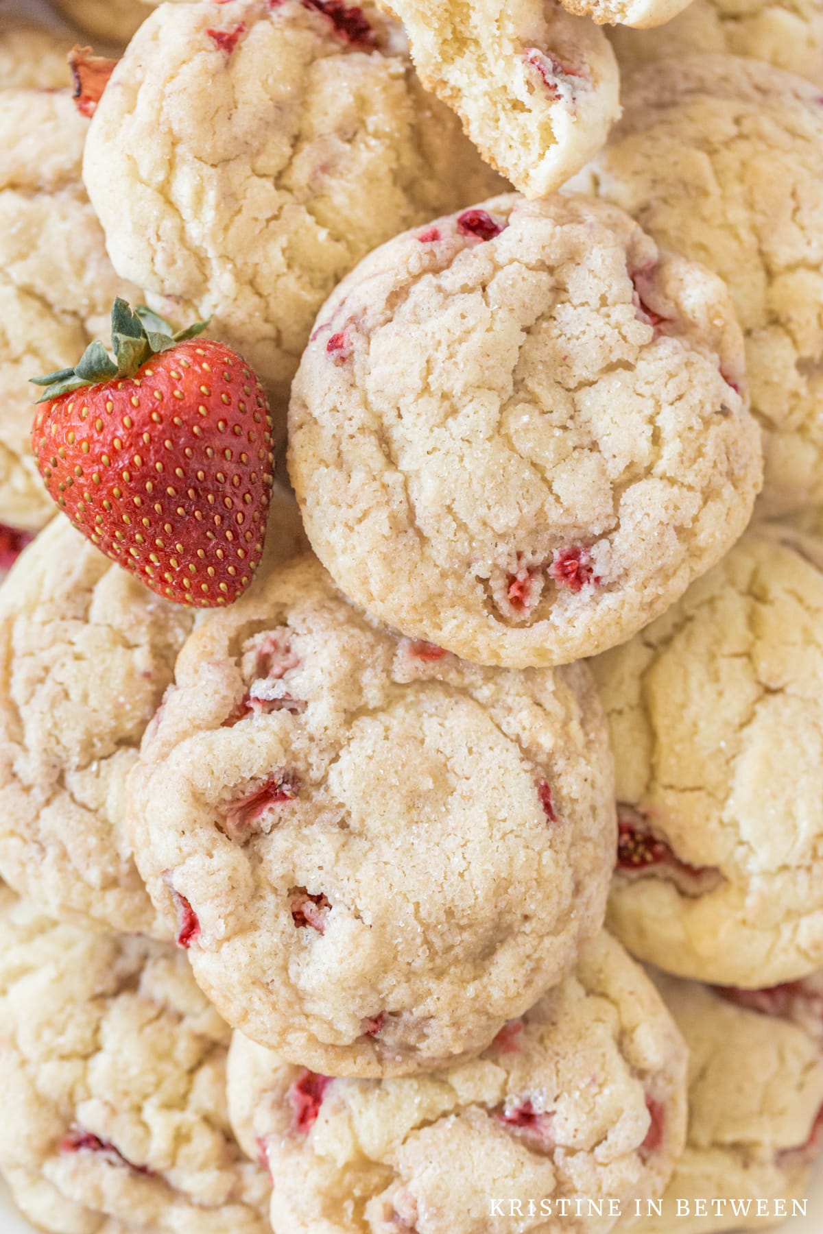 Strawberry sugar cookies stacked up with a strawberry on top.