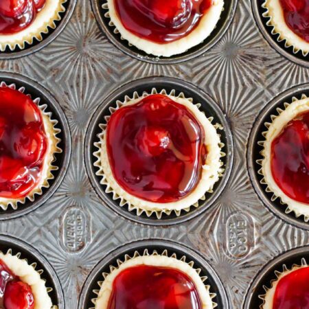 Cherry cream cheese tarts sitting in an antique muffin tin.