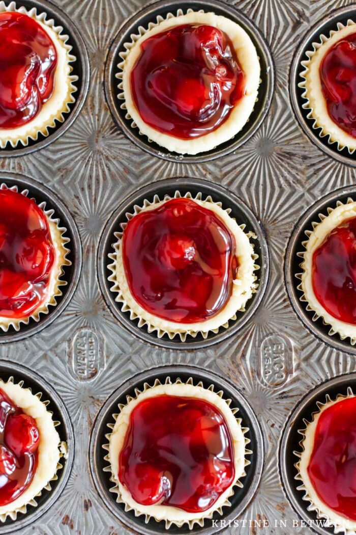 Cherry cream cheese tarts sitting in an antique muffin tin.