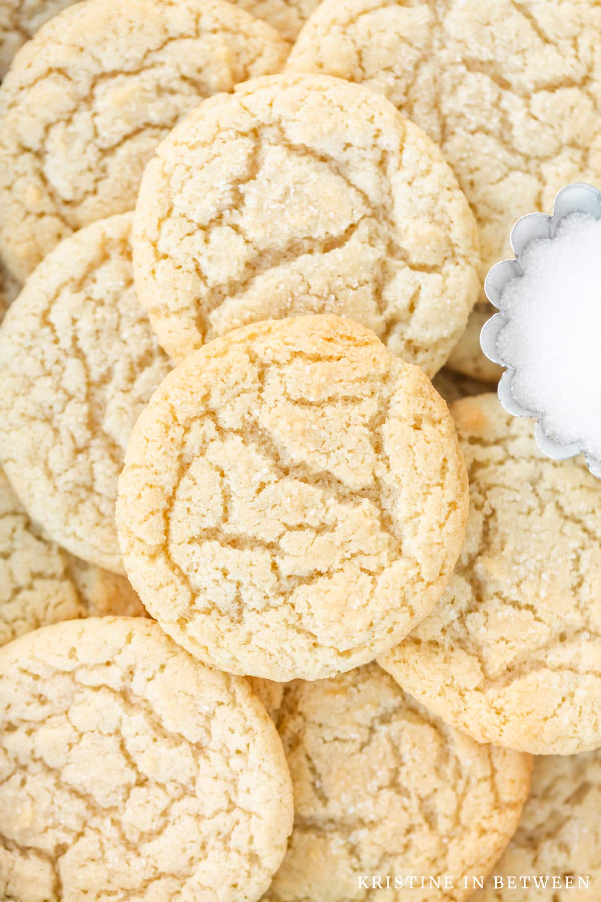 Sugar cookies stacked up on each other showing the detail in the tops of the cookies.
