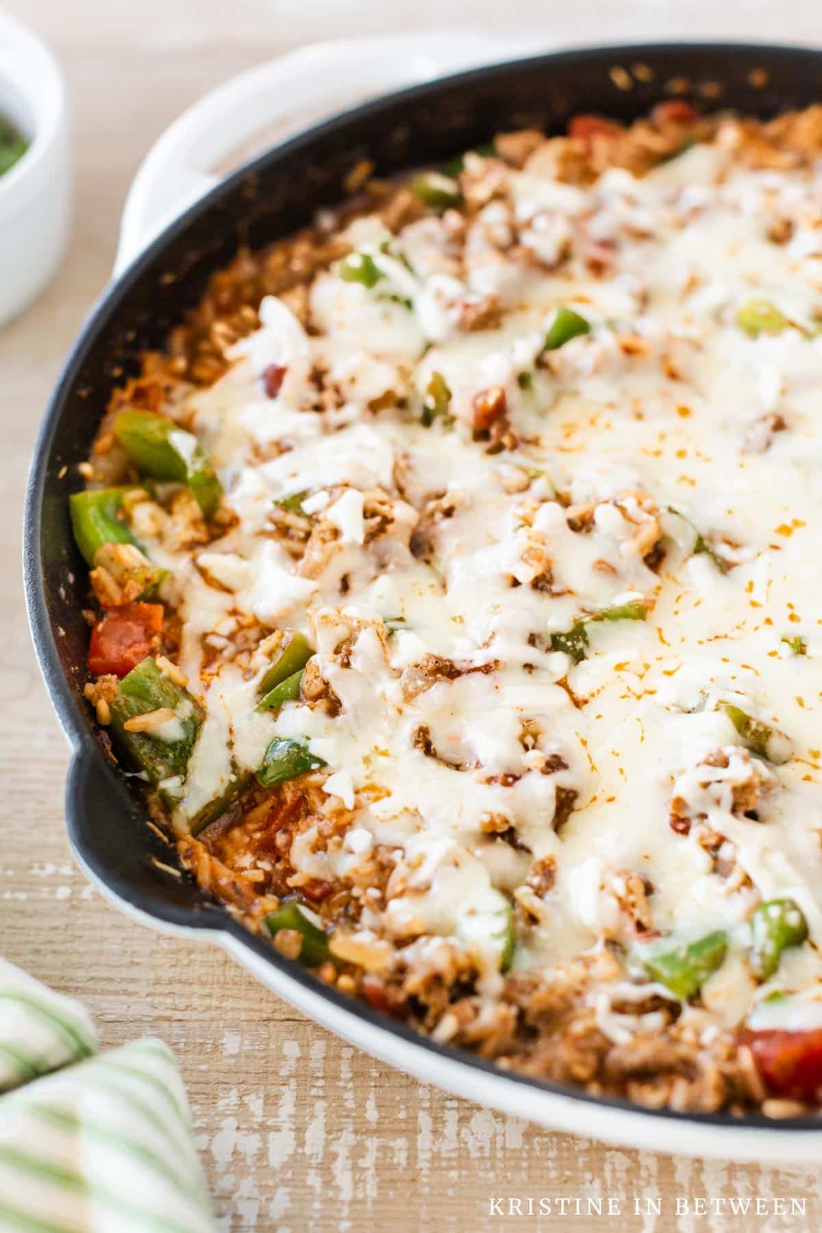 A pan of inside out stuffed peppers covered in mozzarella cheese.
