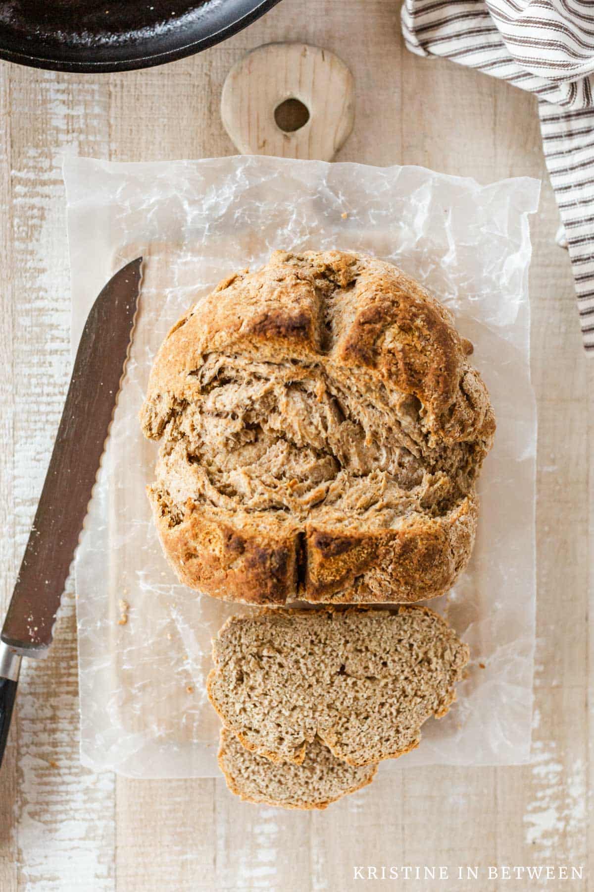 A loaf of Irish brown bread with the end cut off and a knife sitting next to it.