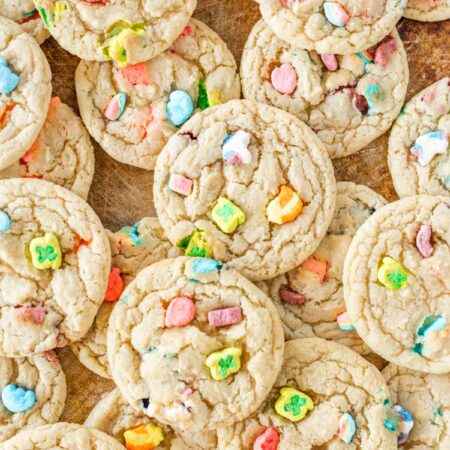 Lucky Charms sugar cookies stacked upon an old baking sheet.