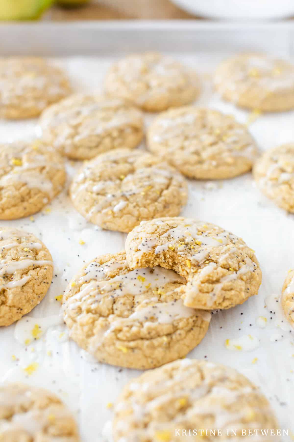 Glazed lemon poppy seed cookies on a baking sheet.