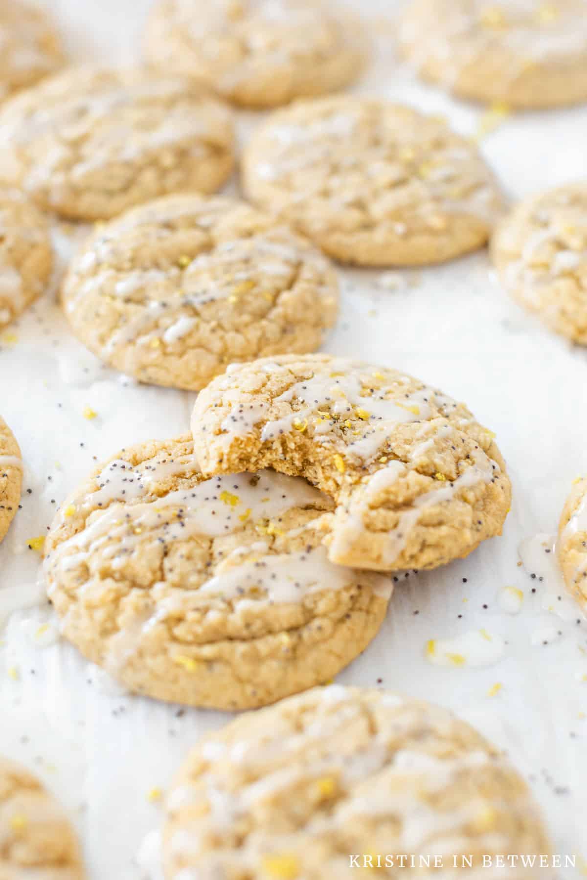 Glazed lemon poppy seed cookies on a baking sheet.
