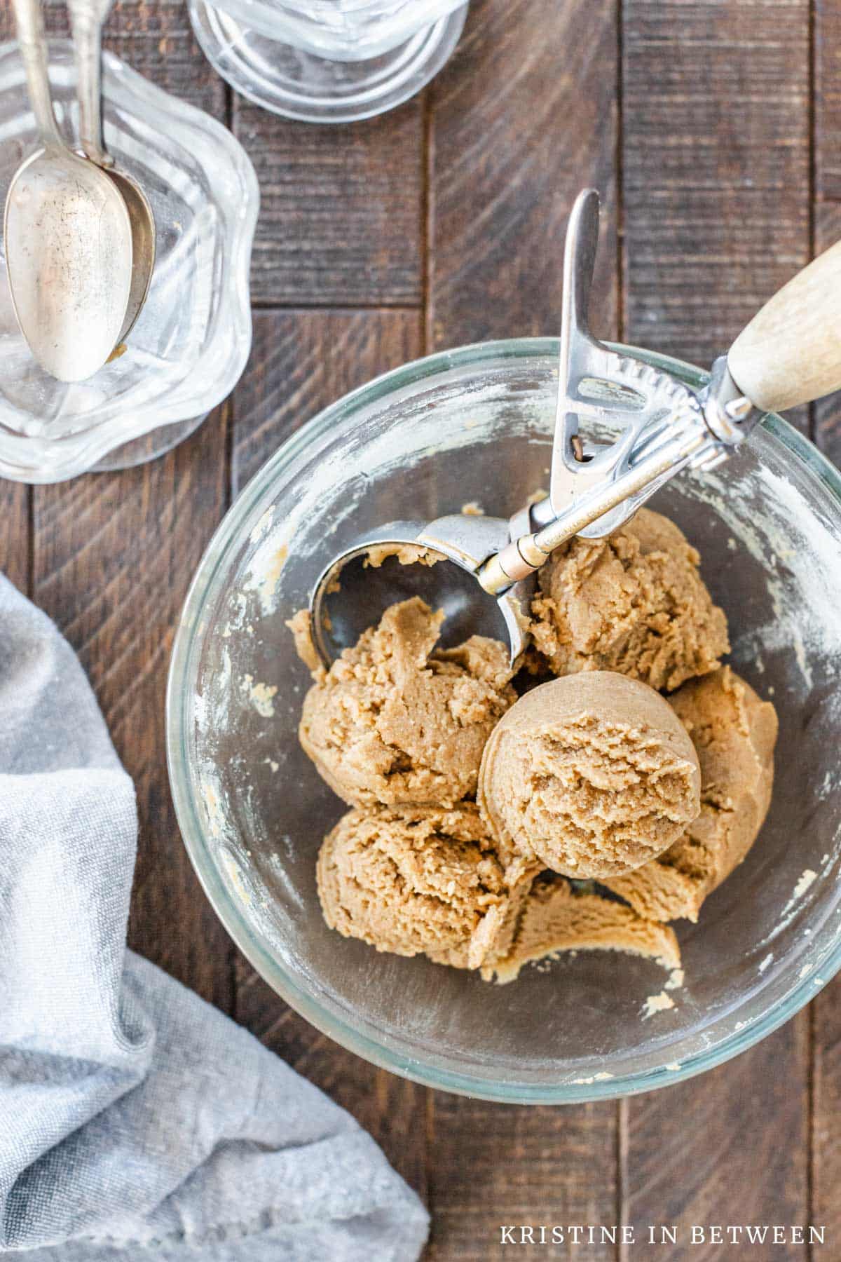 A bowl of edible cookie dough with a scoop in it.
