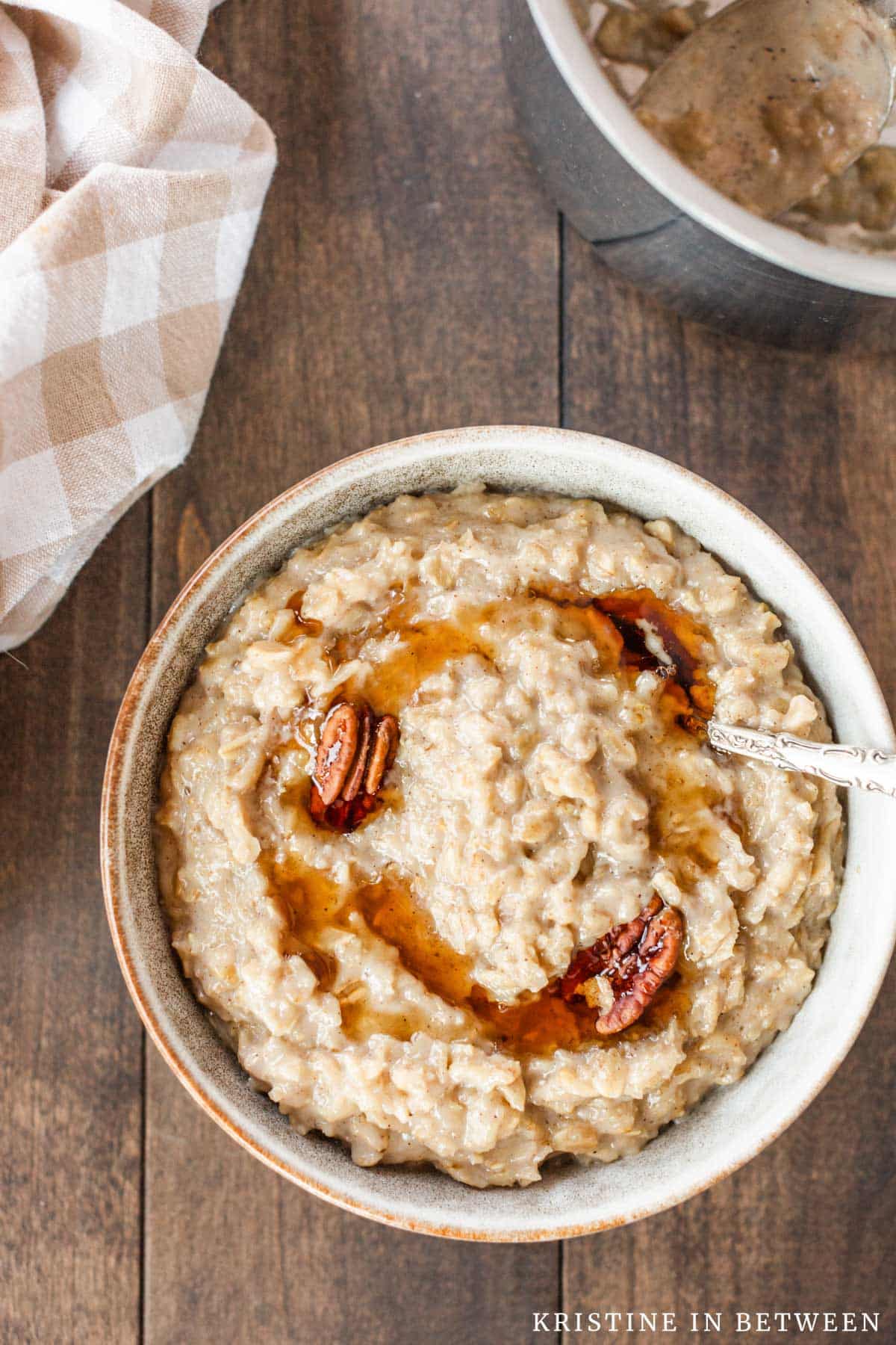 A big bowl of maple and brown sugar oatmeal, drizzled with maple syrup and a few pecans.