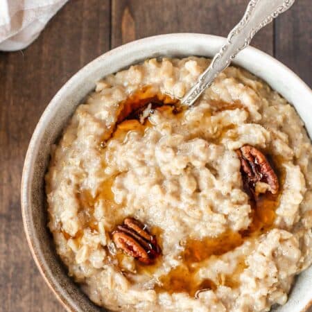 A big bowl of maple and brown sugar oatmeal, drizzled with maple syrup and a few pecans.