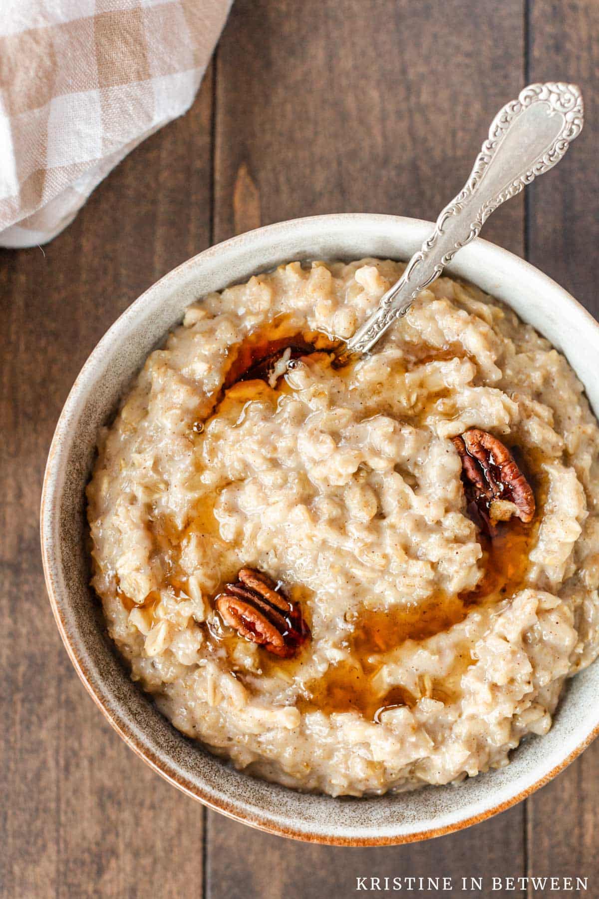 A big bowl of maple and brown sugar oatmeal, drizzled with maple syrup and a few pecans.