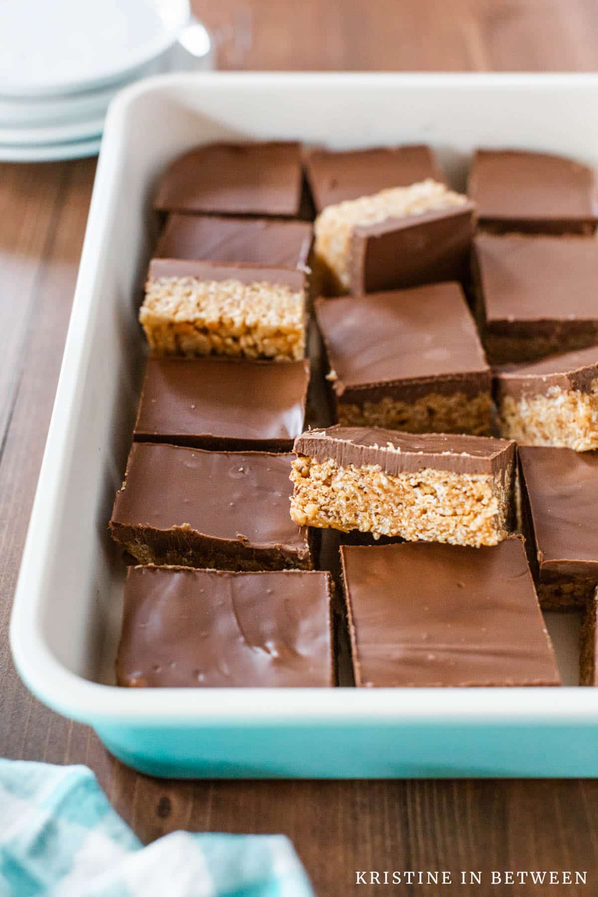 A pan of old-fashioned scotcheroo bars laying with a teal checkered napkin.