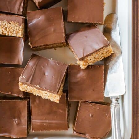 Old-fashioned Scotcheroo bars sliced in a baking pan with an antique spatula.