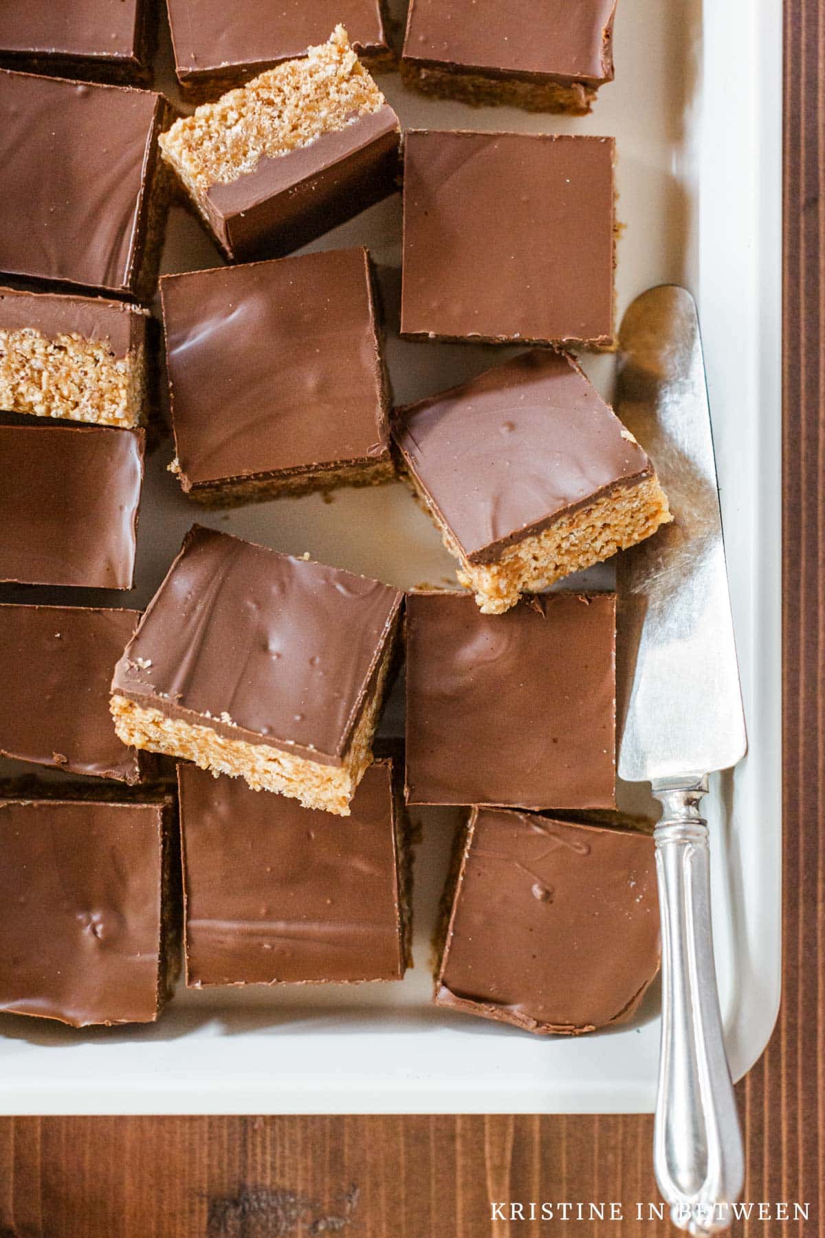 Old-fashioned Scotcheroo bars sliced in a baking pan with an antique spatula.