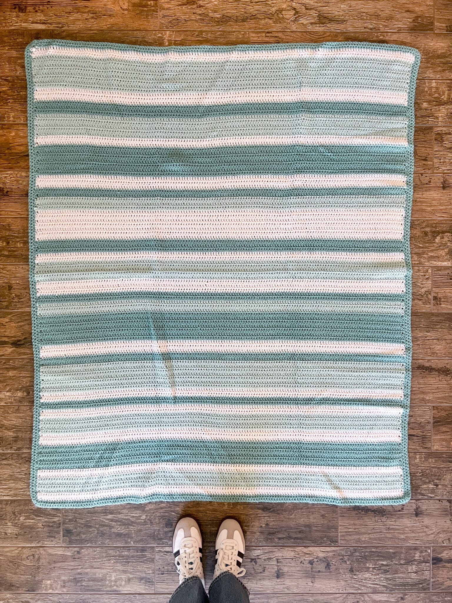 A crocheted afghan laying on the floor.
