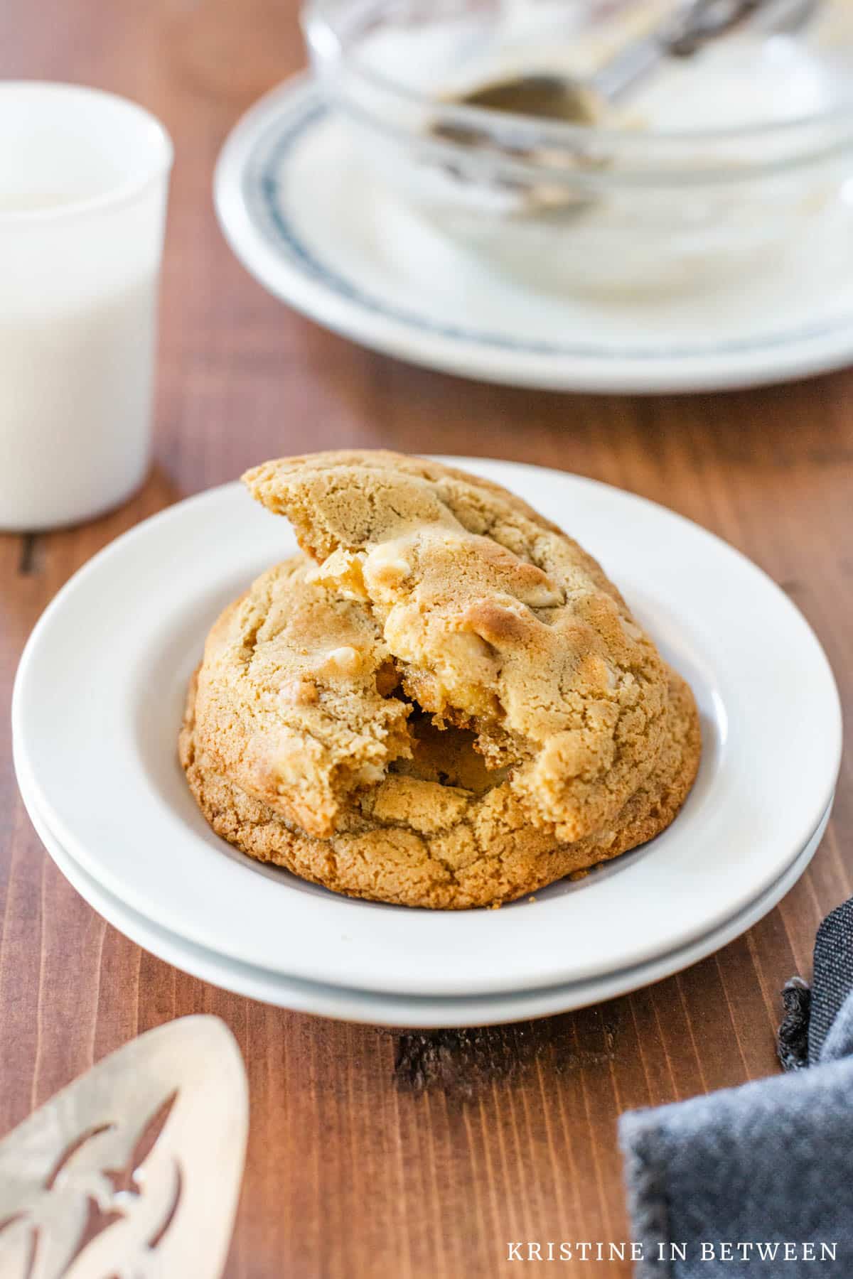 A macadamia nut cookie broken in half to show the inside of the cookie.
