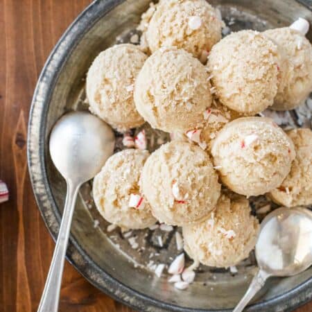 Edible peppermint cookie dough scooped out onto an antique pie plate with two spoons.