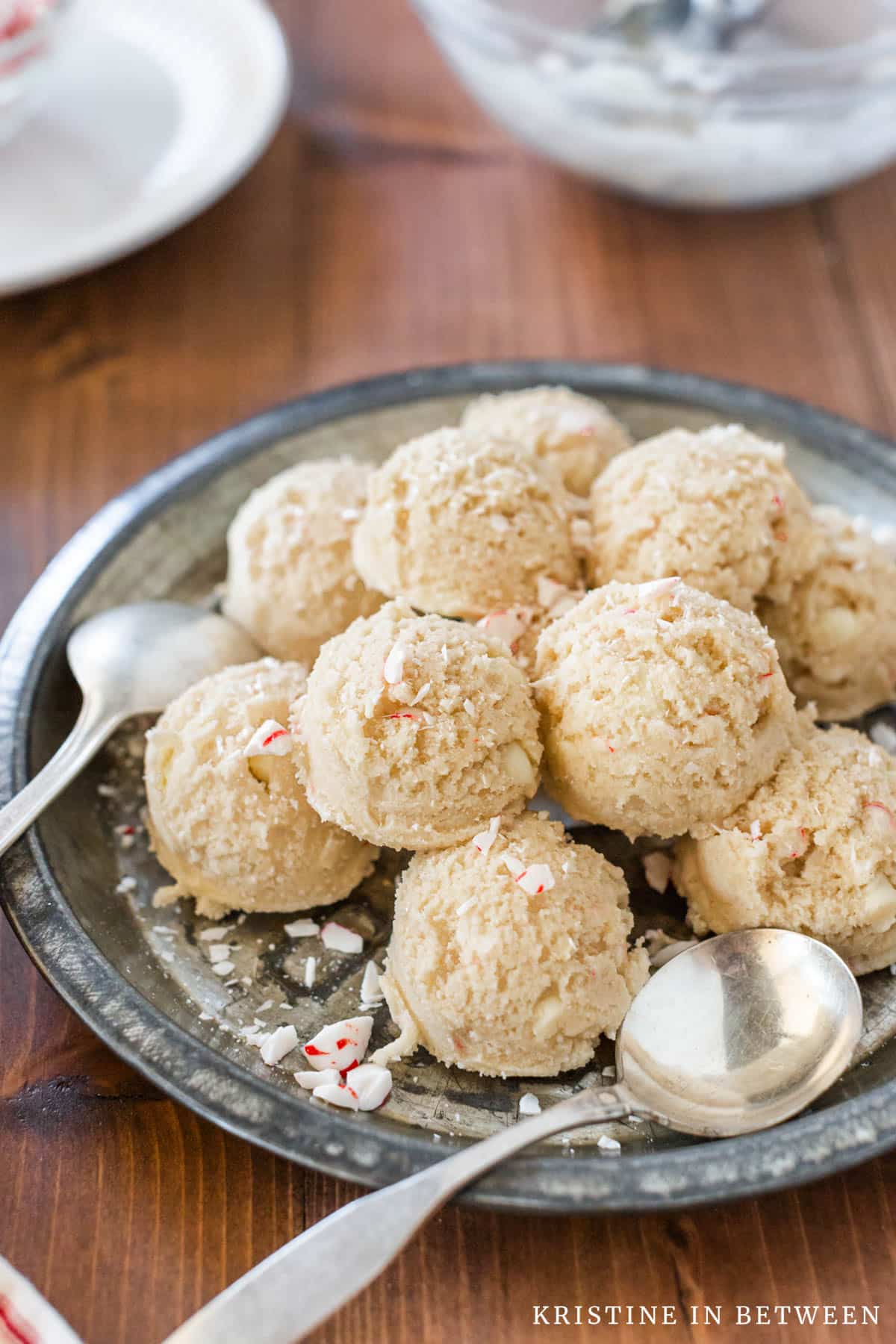 Edible peppermint cookie dough scooped out onto an antique pie plate with two spoons.