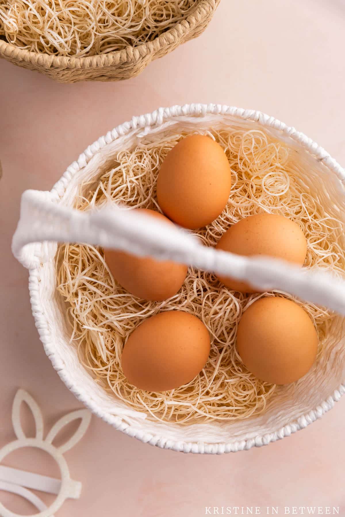 An easter basket with 5 brown eggs inside.