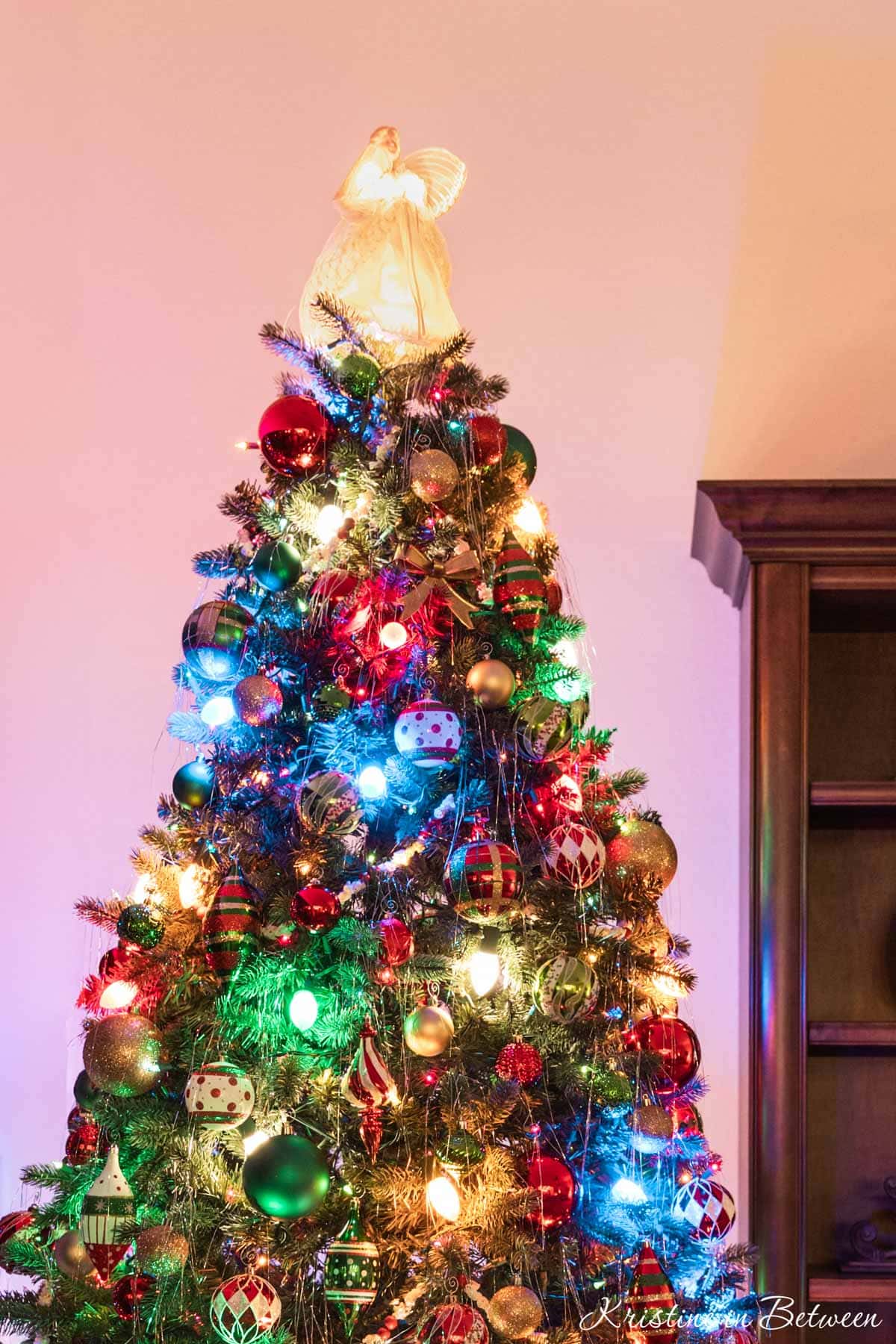An angel on top of a traditional Christmas tree.