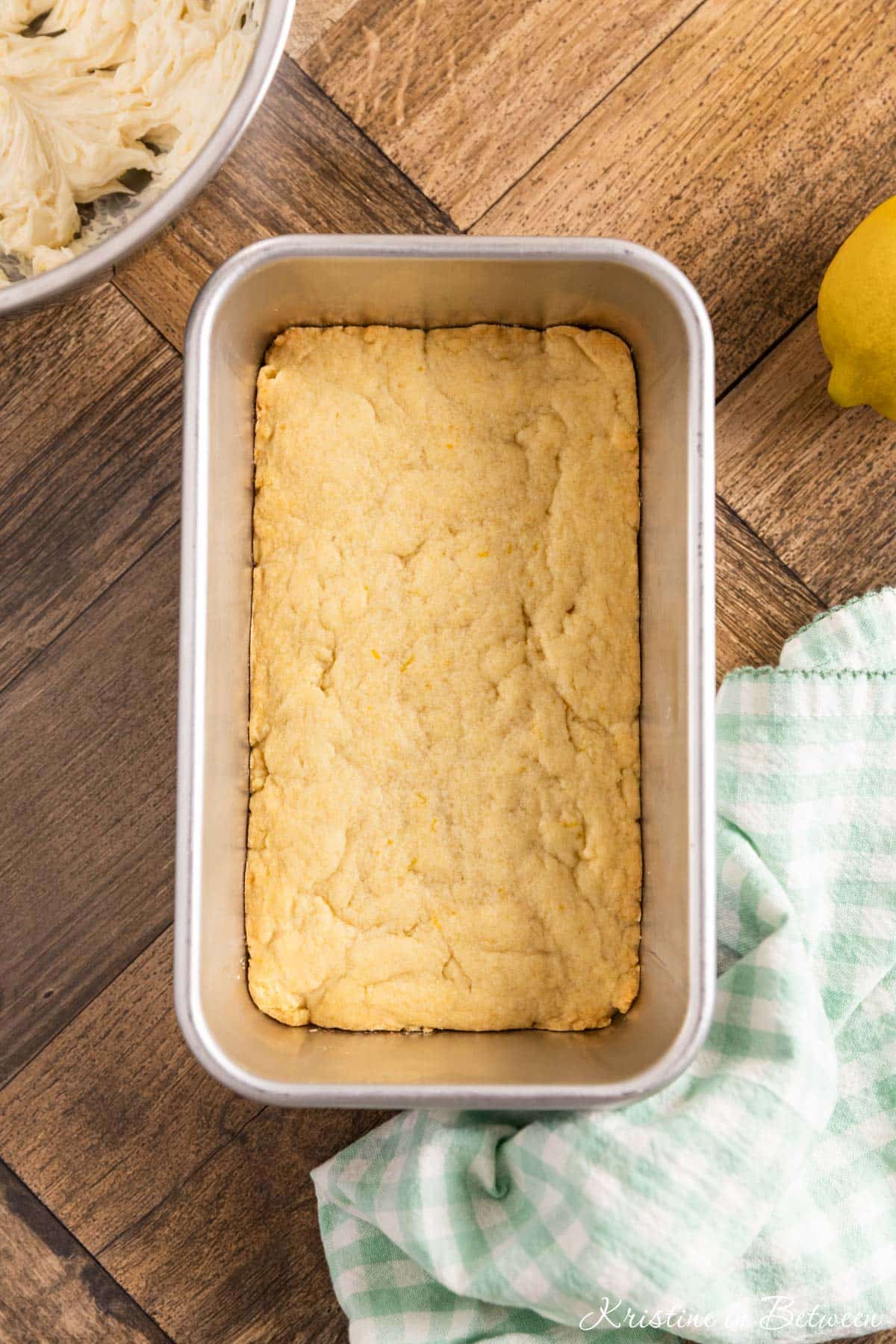 Cookie bars in a metal baking pan with a teal napkin sitting next to it.