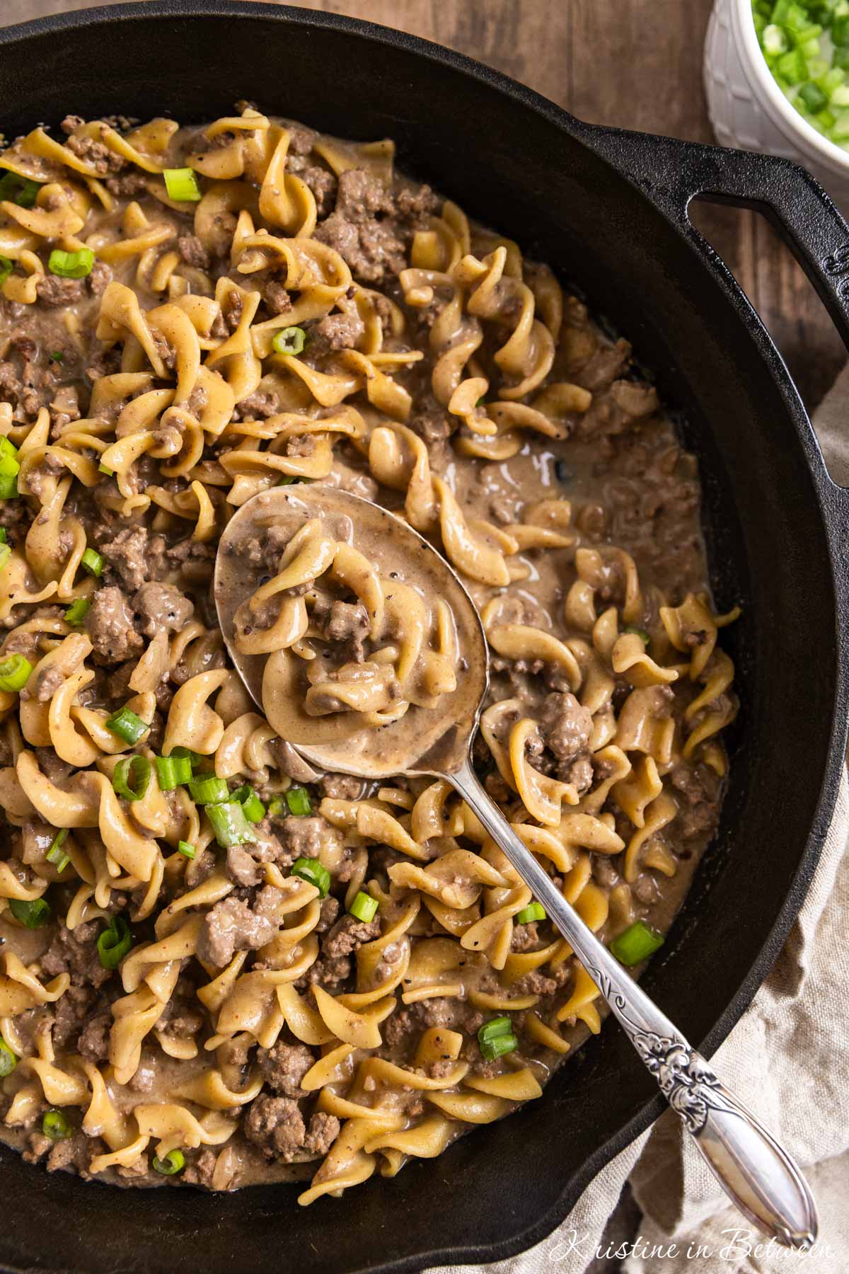 Beef stroganoff in a skillet with a spoon on top, ready to eat.